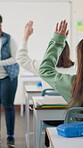 Hand raised, students and classroom as question for teacher in education, growth or development. Female person, university and tuition in lecture, course or module for knowledge, scholarship or skill