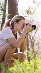 Woman, hiker and photography with camera in woods for sightseeing, tourism or nature hobby. Photographer, person or traveler with lens for picture, memory or photo shoot in forest with technology