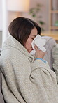 Sick, girl and blowing nose for cold, flu and illness with blanket for wellness and comfort on living room sofa. Woman, sneezing and recovery for health, virus or allergy with rest and relax in house