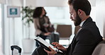 Suitcase, airport and business man on tablet for commute, travel or work trip waiting in lobby. Professional, corporate and worker on digital tech for internet, research and online for transportation