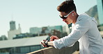 Fitness, music and man in city on break, thinking and check smart watch for exercise progress. Earphones, street and tired runner outdoor for body health, wellness and listening to audio for training