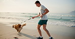 Man, fitness and running with dog on beach for sprint, race or bonding together in nature. Young, male person or owner with pet animal or canine for jog or walk on sandy shore by waves or ocean coast