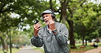Headphones, winning and old man in park with phone, good news or happy giveaway notification. Streaming, yes and excited senior person in garden with smartphone, fun celebration or retirement bonus