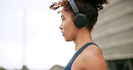 Fitness, profile and headphones with woman and skipping rope in city for workout, streaming podcast or challenge. Health, energy and exercise performance with person jumping in town for wellness