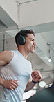 Treadmill, workout and headphones with man in gym for marathon training, streaming and fitness club. Health, wellness and speed challenge with person in sports center for running, music and cardio