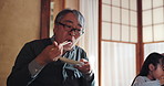 Grandfather, Japanese family and child at lunch for food, happiness and bonding together for eating. People, girl and home for healthy meal, diet and nutrition in dining room at table with chopsticks