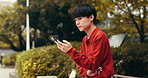 Japanese, typing and man on bench, smartphone and internet with social media, texting and relax. Asian person, outdoor and guy with cellphone, mobile user and message to contact, connection and app