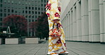 Woman, legs and walking in Japan with traditional clothes, outfit and fashion as model or creative. Female person, feet and dress for style, culture and kimono in town for travel or adventure in city
