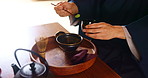 Tea ceremony, person and hands with powder for preparation, ritual and traditional healing in Japan. Japanese man, ceramics and matcha in home for detox beverage, antioxidants and zen in culture