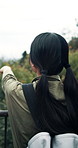 Woman, hiking and back view in nature for vacation, travel or sightseeing with Japanese friends on trip together. Girl, backpack and pointing at forest for trekking, holiday or adventure for tourism