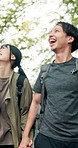 Happy couple, hiking and pointing outdoor for bonding, love and support with travel, holiday and relationship. Man, woman and holding hands as laughing in Japan for natural retreat, vacation and joke