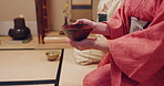 Hands, woman and Japanese herbal tea in cup at traditional ceremony or event for spirituality in Japan. Closeup, cultural clothes and heritage attire with teapot for matcha beverage and flavor
