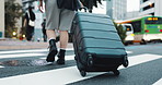 Feet, travel and back in street with suitcase, direction and luggage for vacation on urban crosswalk. Person, tourist and holiday with baggage, location and commute to hotel on metro road in Japan
