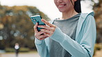 Hands, sports and woman with phone in park searching for online exercise program for health. Fitness, cellphone and female athlete typing on browsing website for workout routine outdoor in Japan.