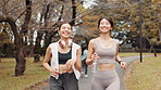 Asian women, fitness and running with water at park for workout, cardio exercise or training in nature. Active friends, japanese runner or female people with smile for health and wellness on path