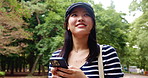 Japanese woman, park and thinking with smartphone for social media, mobile notification and walking in nature. Asian girl, phone and search online for travel, communication and internet message