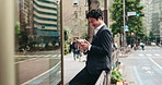 Business man, smartphone and happy in city, thinking and reading for negotiation, deal or texting on fence. Person, phone and scroll on mobile app, notification or networking on urban road in Japan