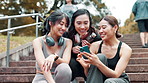 Fitness, phone and steps with Japanese friends outdoor together for cardio, training or workout. Break, exercise and smile of athlete women on stairs for communication, tracking or update with app
