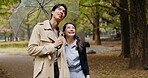 Umbrella, smile and Japanese couple in park for love, partner and bonding together. Commitment, support and happy with asian man and woman on date in nature path for care, honeymoon and vacation