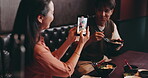 Restaurant, food and couple with phone screen for photography, culinary memory and bonding together. Japanese people, man and woman with mobile app for recording, video and partner for eating noodles