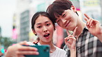 Happy, asian couple and selfie with peace sign in city for memory or picture together in Tokyo. Japanese, man and woman with smile, expression or emoji for capture, moment or travel in an urban town
