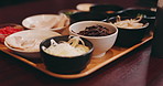 Food, japanese or cuisine with tray at restaurant for assorted dish, variety or range of meals on table. Closeup, empty or gourmet asian dinner with bowls for catering service or dining in Japan
