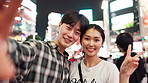 Happy, asian couple or night with selfie in city for memory or picture together in Tokyo. Portrait, japanese man and woman with smile or peace sign for photography or moment in an urban town of Japan