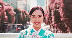 Japanese woman, face and kimono in city with fashion, confidence and pride for culture. Girl, happy or portrait in urban Tokyo with traditional attire, heritage or indigenous style with smile in town