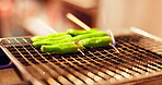 Japanese green pepper, vegetables and shishito on grill for traditional cuisine, savory dish and cultural snack. Food, cooking and skewer appetizer for healthy meal, heritage and culture with fire