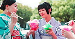 Women, outdoor and eating dessert at Japan festival with sharing slush drink, taste test and enjoyment in kimono. Traditional fashion, people and friends with kakigori ice for refreshment and culture