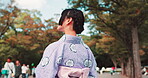Japan, girl and fashion with sightseeing in park for travel, nature scenery and gratitude for heritage or culture. Woman, smile and fresh air in kimono with traditional journey, wonder or daydreaming
