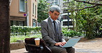 Mature, businessman and typing on laptop at park for case review, legal administration and writing report. Professional, lawyer and law research outdoor in city for client policy update or contract