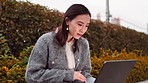 Woman, bench and laptop outdoor with email, tech and working online with remote professional. Japanese, park and digital writer with creative project, typing and happy in Tokyo with technology