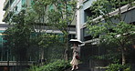 Stairs, walking and woman in city with umbrella, winter trees and professional on morning commute in business park. Rain, cover and Japanese businesswoman on steps of office building for urban travel