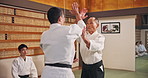 Asian man, aikido and martial arts with sensei for self defense training, practice or technique in dojo. Japanese, male people or trainer with traditional bow for fight, karate or taekwondo lesson