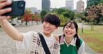 Students, selfie and Asian couple in city for travel, commute and walking in urban park. Love, weekend and happy Japanese man and woman take photo for social media, internet post and update outdoors