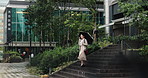 Business, phone call and woman in city with umbrella, discussion and morning commute on steps. Rain, cover and Japanese businesswoman with smartphone, communication or urban travel on building stairs