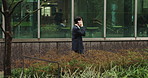 Phone call, walking and man in business park with discussion, contact and talking on morning commute. City, office building and Japanese businessman with smartphone, communication and urban travel