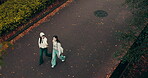 Women, walking and road of town in Japan, talking and friends travel together in nature. People, conversation and adventure or urban journey on street, top view and outdoor hangout for bonding trip