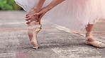 Hands, feet and stretching for ballet, outdoor and warm up for performance, concert or street art. Person, dancer or ballerina with ankle, prepare and ready for training at urban park in Japan