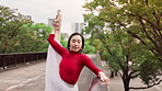 Woman, ballet and stretching outdoor at park, bridge and warm up muscle for performance in spring. Person, dancer and balance with legs, creativity and ready for show, talent and street art in Japan