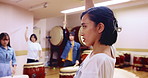 Religion, woman and playing of taiko, art and professional with sticks for performance and teaching. Serious, artist and Japanese people with instrument, talk and teacher in class, talent and music