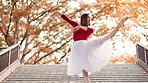 Japanese, woman and dancing on park steps with balance, moving and public performance. Creative, dancer and autumn with Asian culture, tradition and celebration custom on city stairs with music