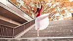 Japanese, woman and ballet dancer on park steps with balance, moving and public performance. Creative, dancing and autumn with culture, spin and Japan custom on city stairs with music and low angle
