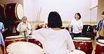 Japanese, women and teacher with drum or instrument for taiko tradition, culture or practice. Asian, female people or musicians with sound, sticks or wooden equipment for percussion class in Japan