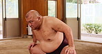Man, japanese or sumo wrestler with slam in ring for technique, balance or preparation in dojo. Male person, fighter or wrestling martial artist with power stance, training or getting ready for arena