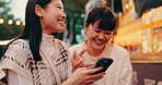 Laughing, friends and Japanese women with smartphone, city and funny videos on app, browsing and digital. Mobile, smile and bonding with gossip, social media and 
people on holiday, humor and Japan