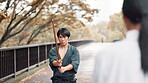 Wood, sword and Japanese man in martial arts training, culture and traditional sports on bridge at park. Bamboo katana, samurai and practice outdoor, aikido exercise or battle technique with partner