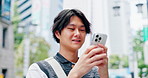 City, smile and phone of japanese man with social media, scroll and map direction app by crosswalk. Street, urban and online with technology, sightseeing and notification check outdoor on road