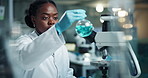 Scientist, black woman and microscope with beaker swirl for research, experiment and medical chemistry. Chemical analysis, expert and liquid with inspection for pharmaceutical study and report